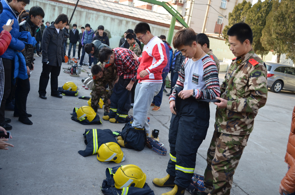 5.在消防战士的指导下同学们试穿消防服.JPG